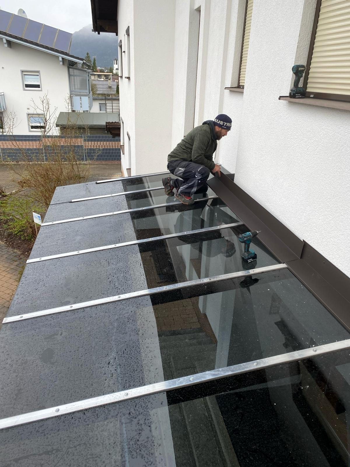 Glasvordach mit schwarzen Scheiben