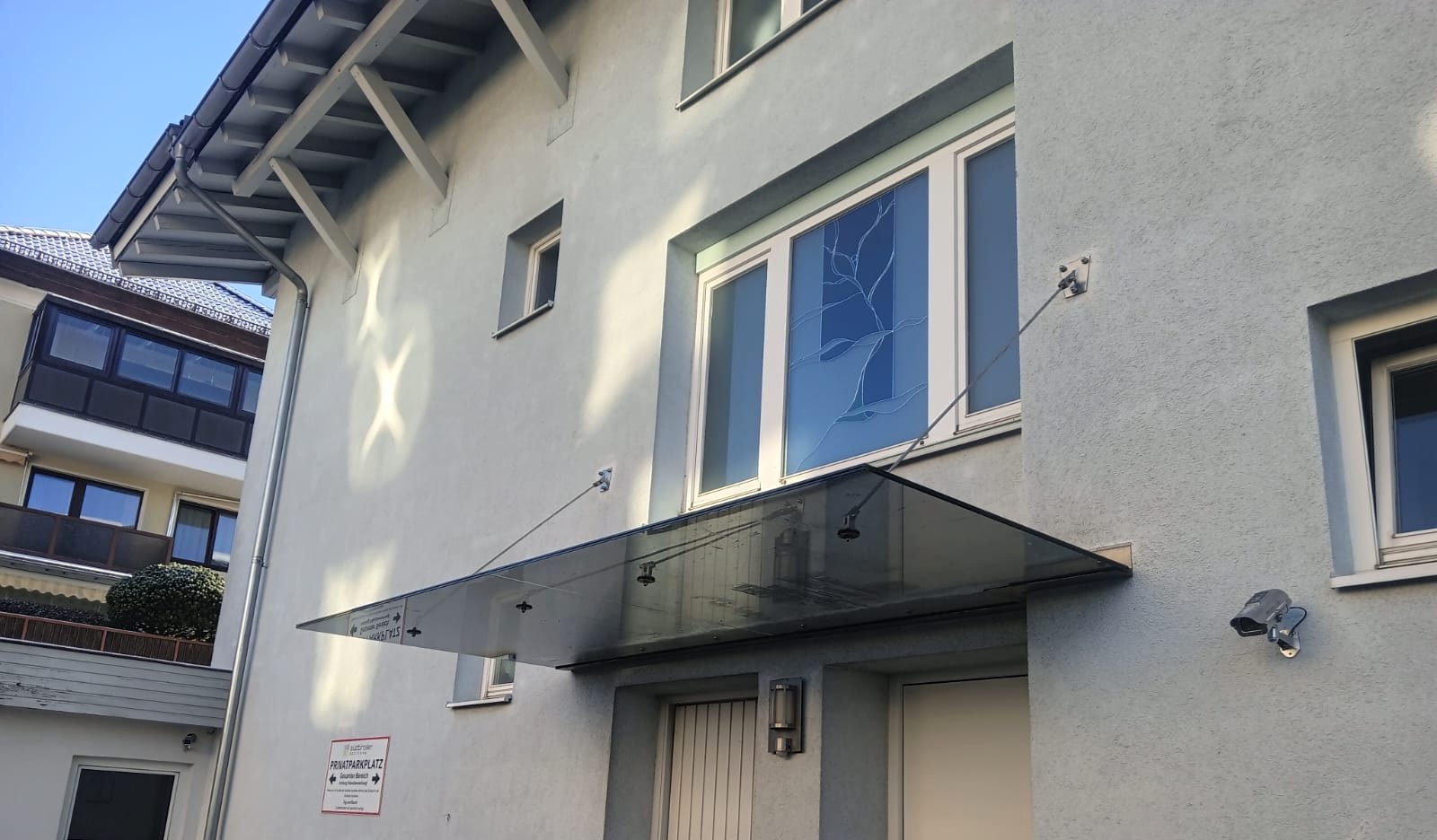 Eingangsüberdachung aus Glas und Metall